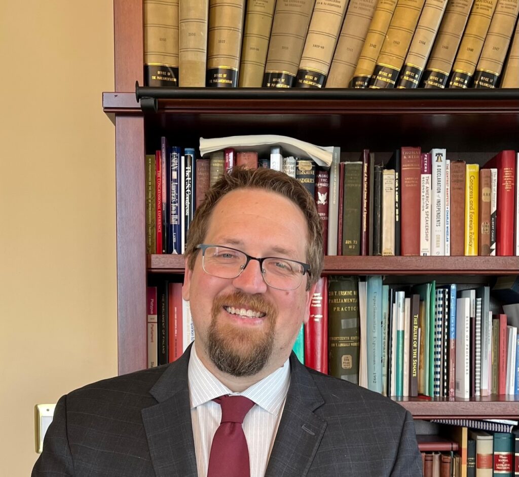 headshot of Jason Smith in front of a bookcase