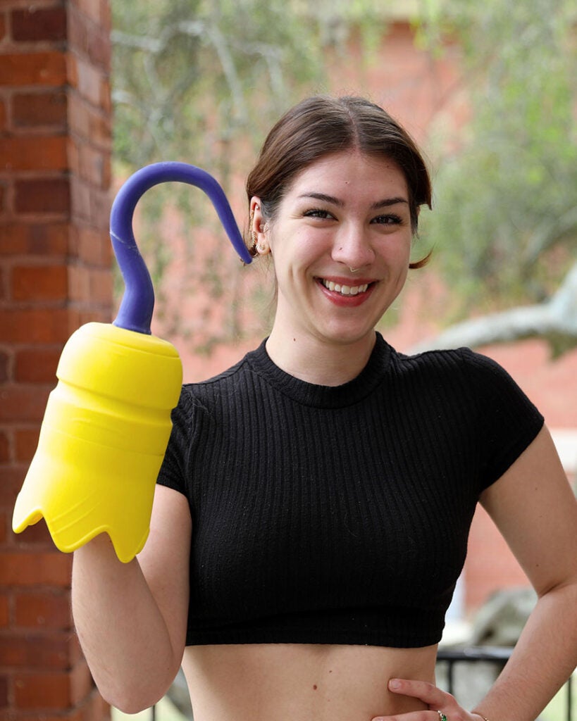 female student in a black top holding a 3d printed hook