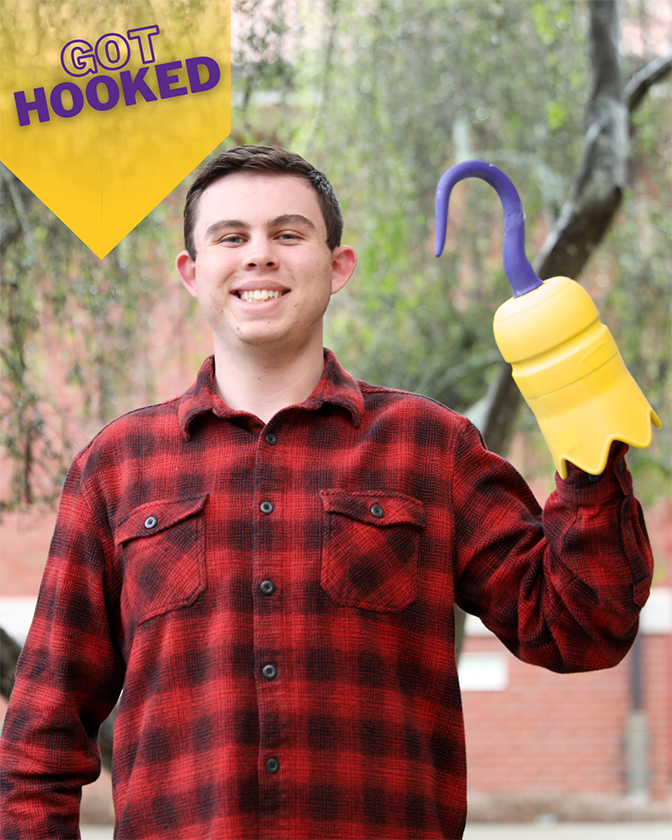 male student wearing a flannel shirt and holding a 3D printed hook
